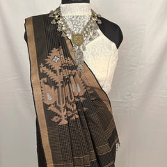 Mannequin wearing a black and golden saree with intricate patterns on a white background