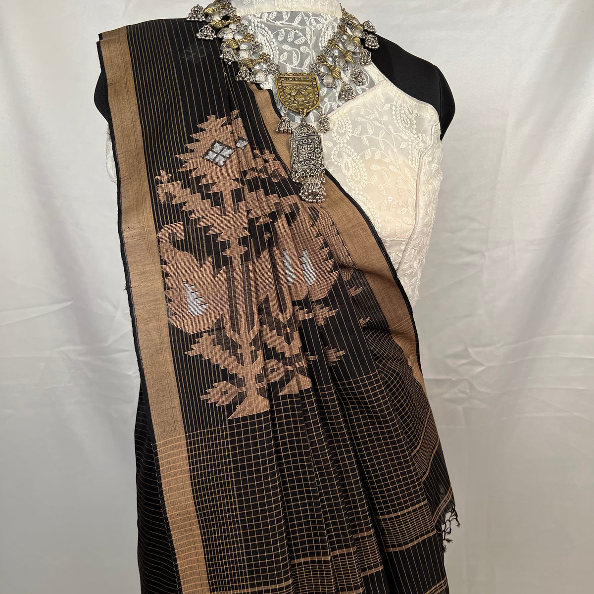 Black and golden embroidered scarf on a mannequin with a white background