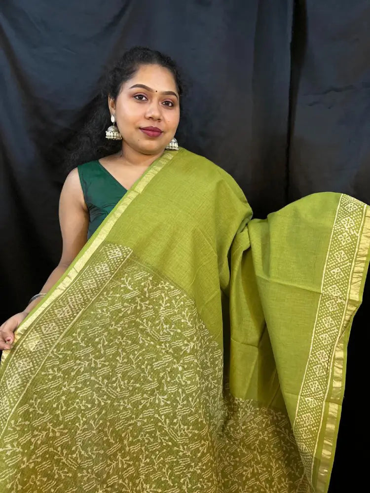 Lightweight green cotton Kota saree displayed on hanger