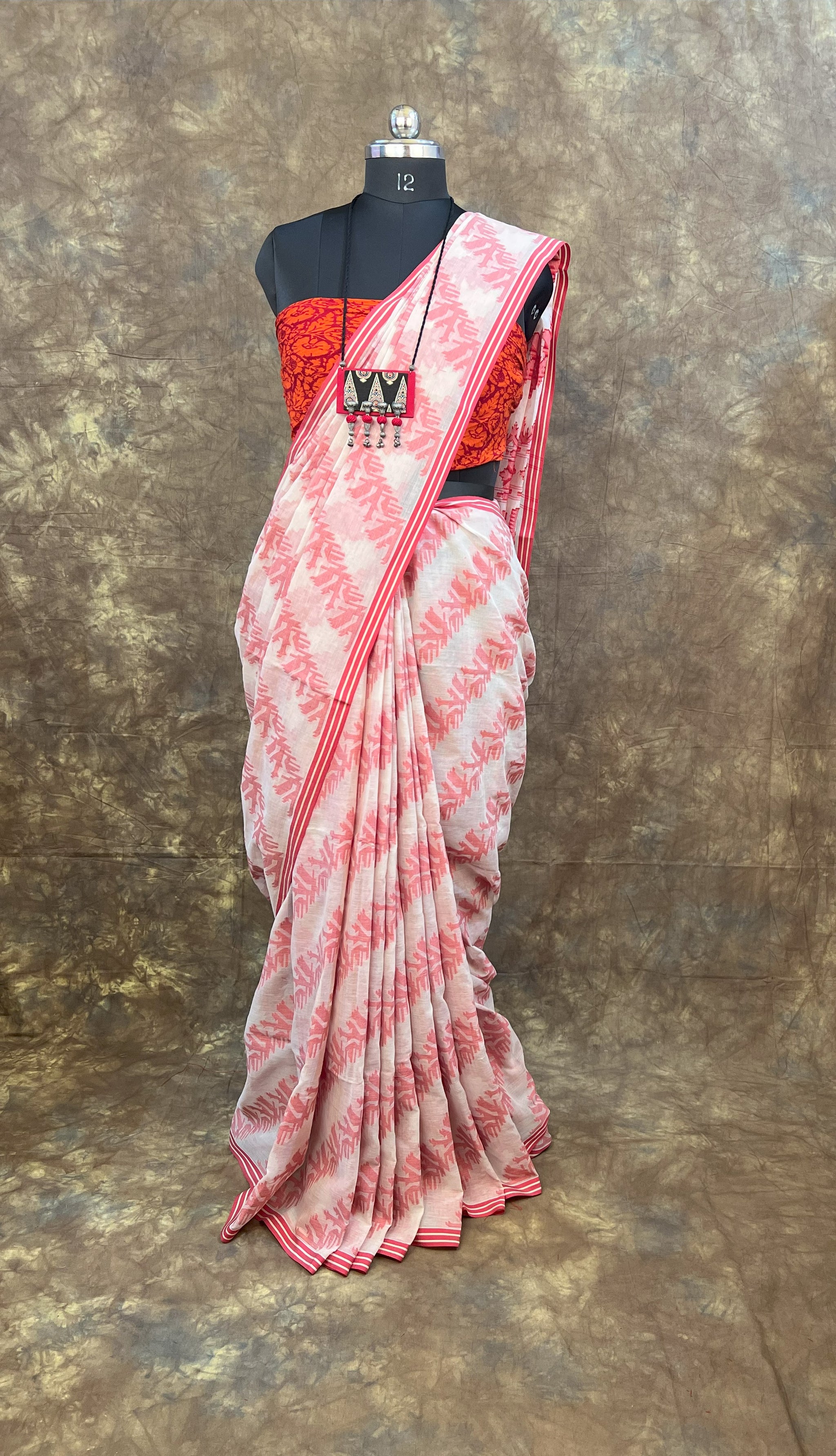 Back view of red white handloom cotton saree styled in traditional Bengali drape