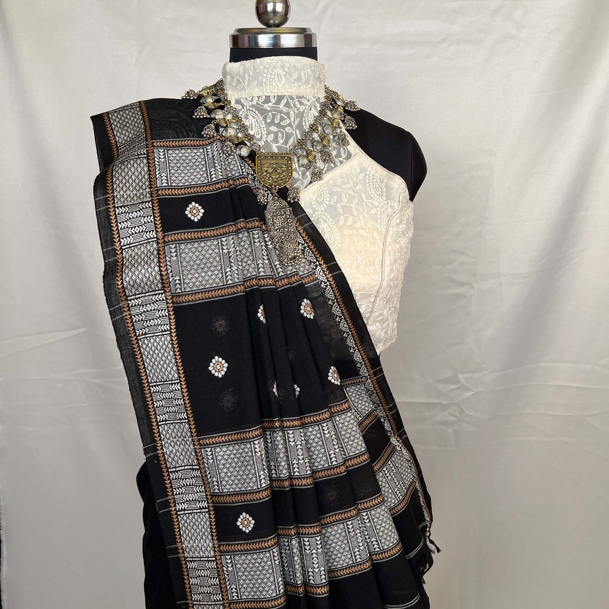 Black and white patterned scarf on a mannequin against a white background