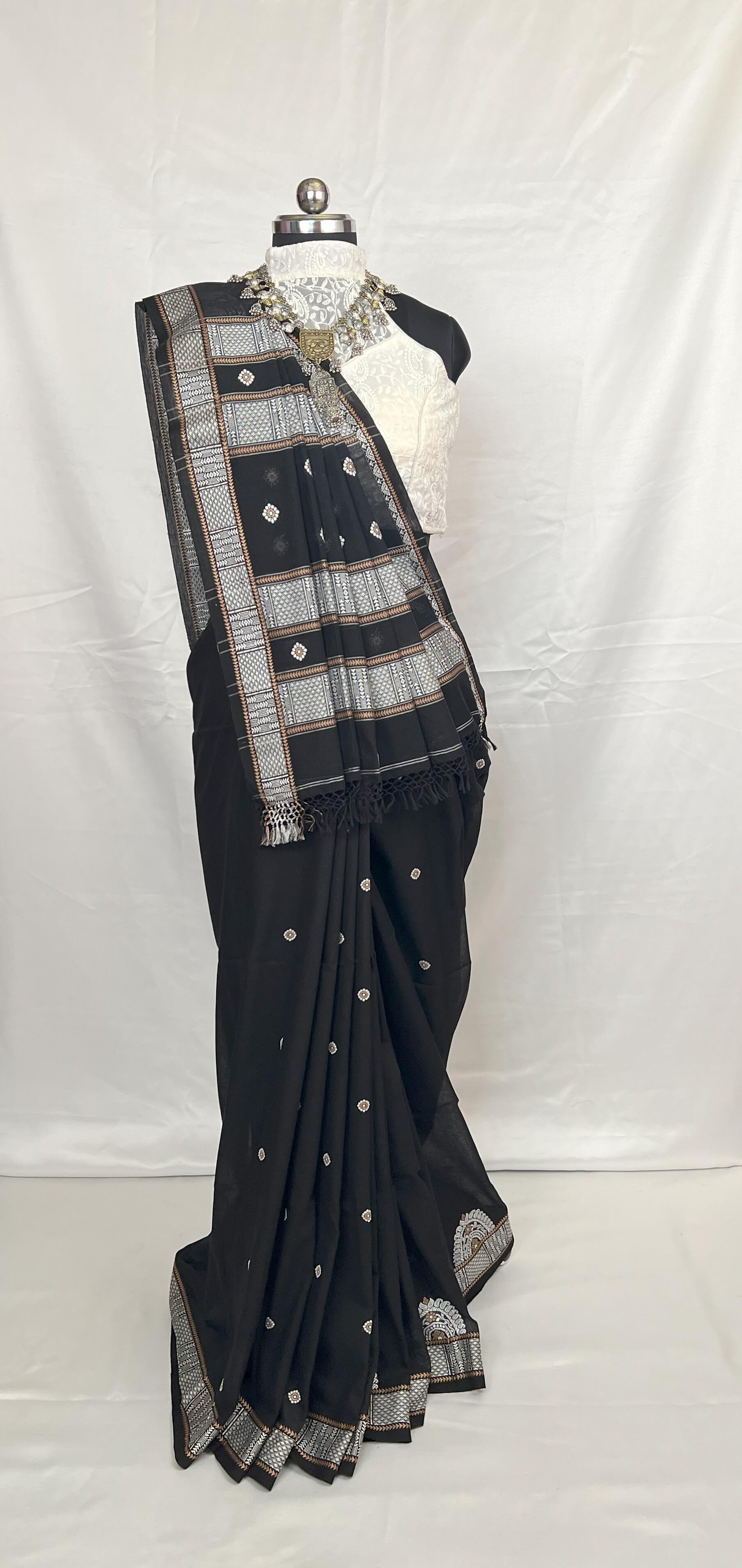 Black saree with silver patterns on a mannequin against a white background