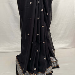 Black saree with white and gold embroidery on a white background
