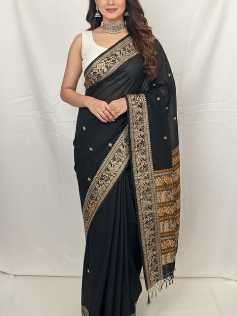 Woman wearing a black saree with gold embroidery on a white background