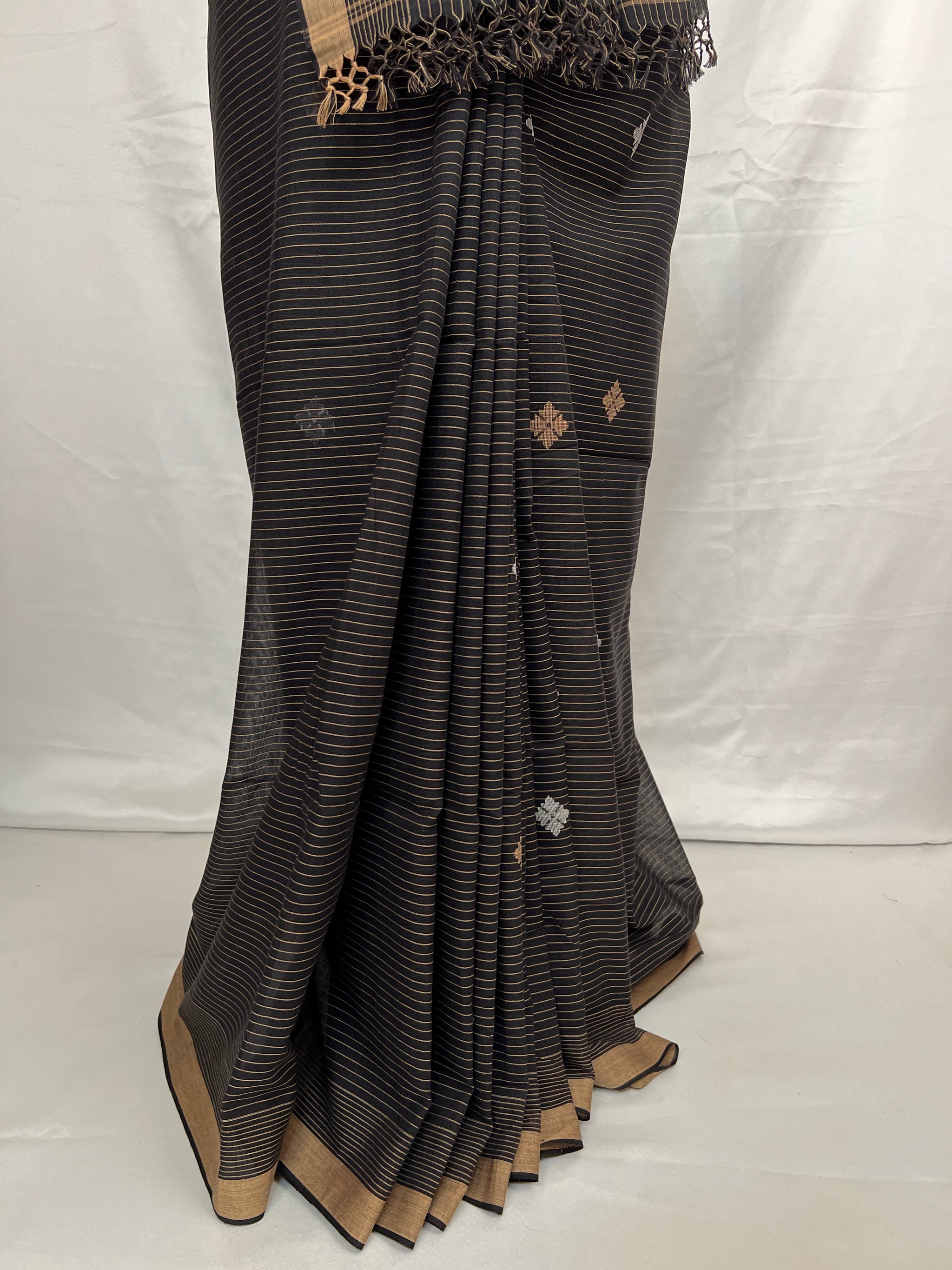 Black and golden striped saree with gold border on a white background