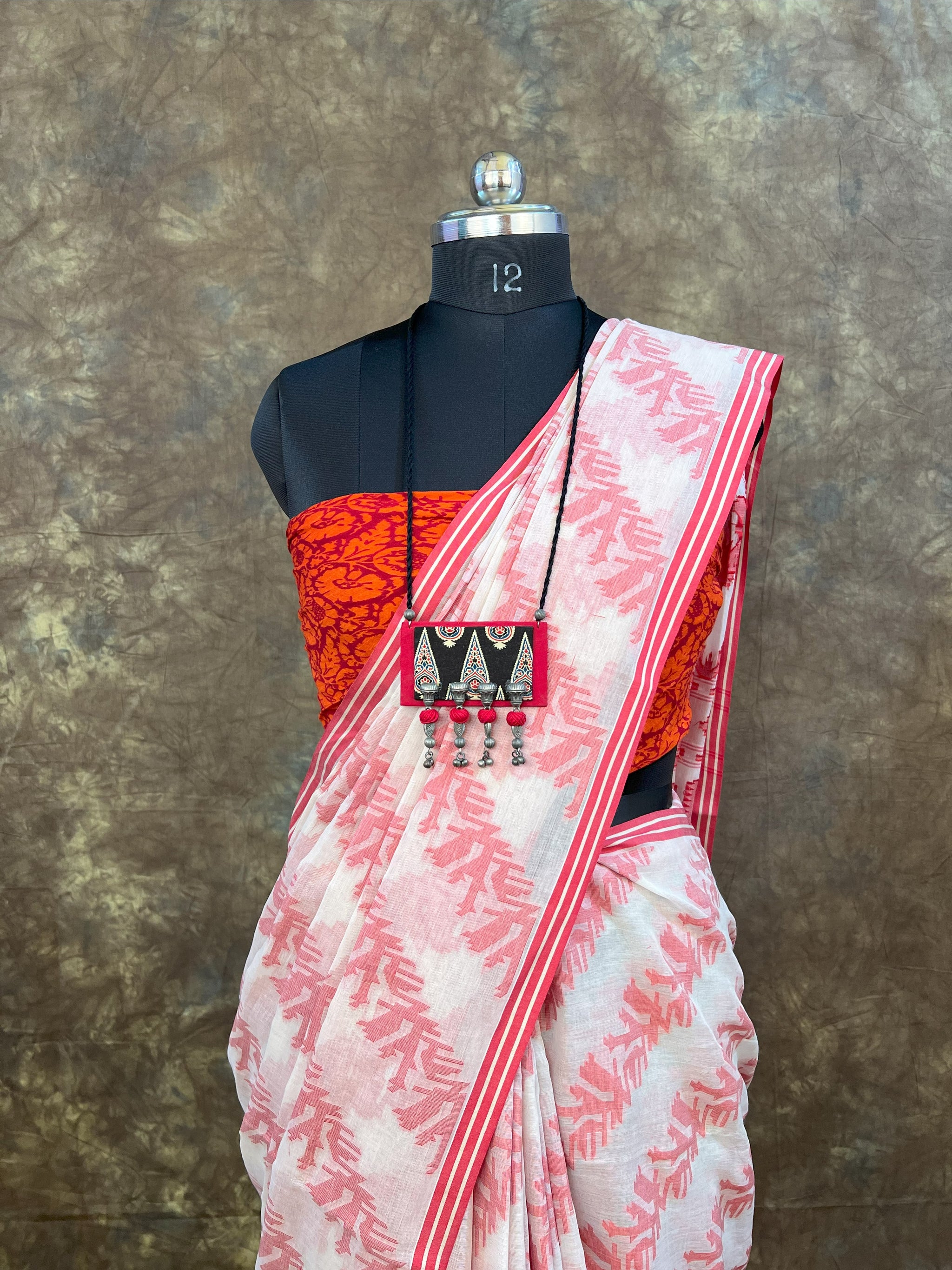 Close-up of intricate weaving details on red white handloom cotton saree.