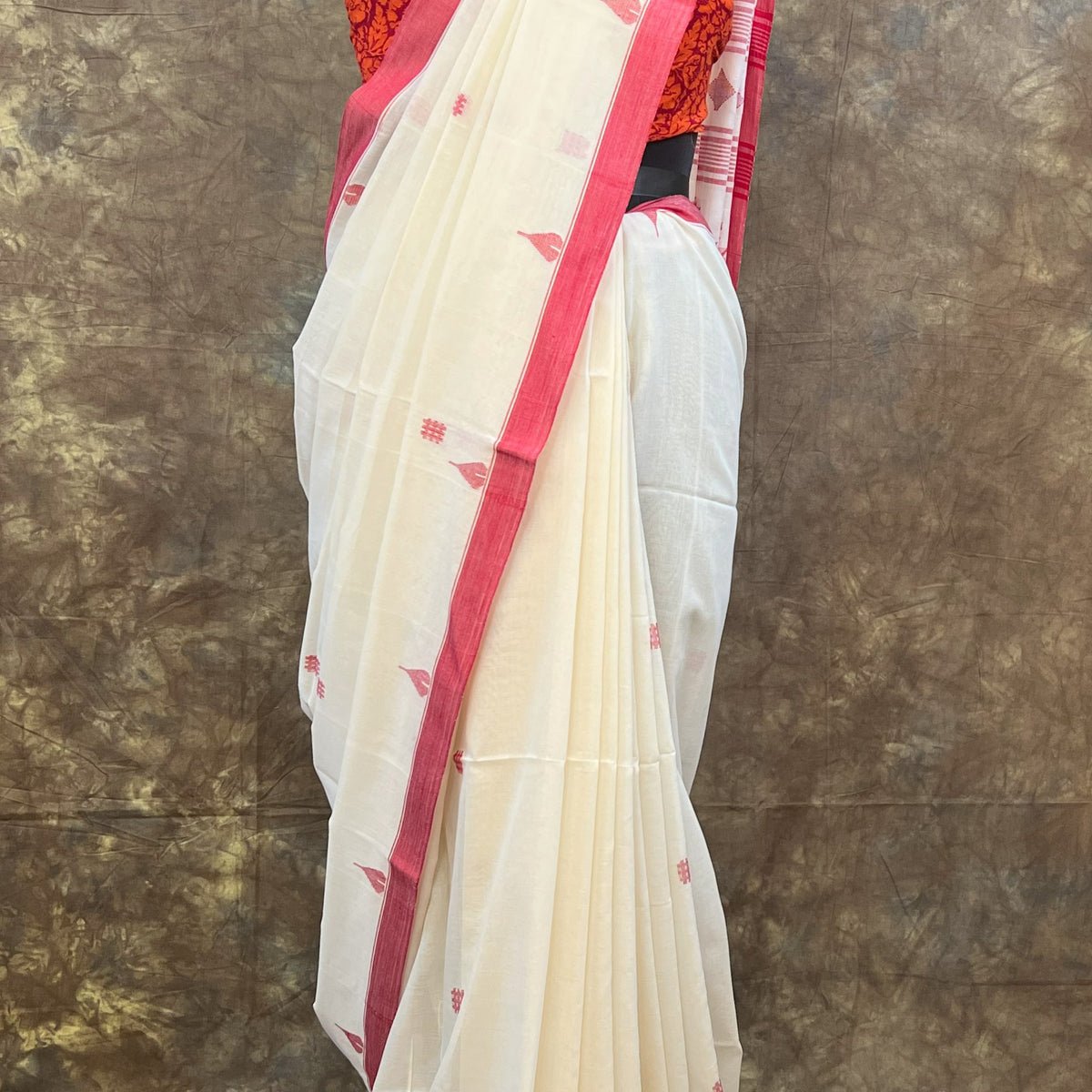 Designer red and white saree with traditional Bengali border for Puja.