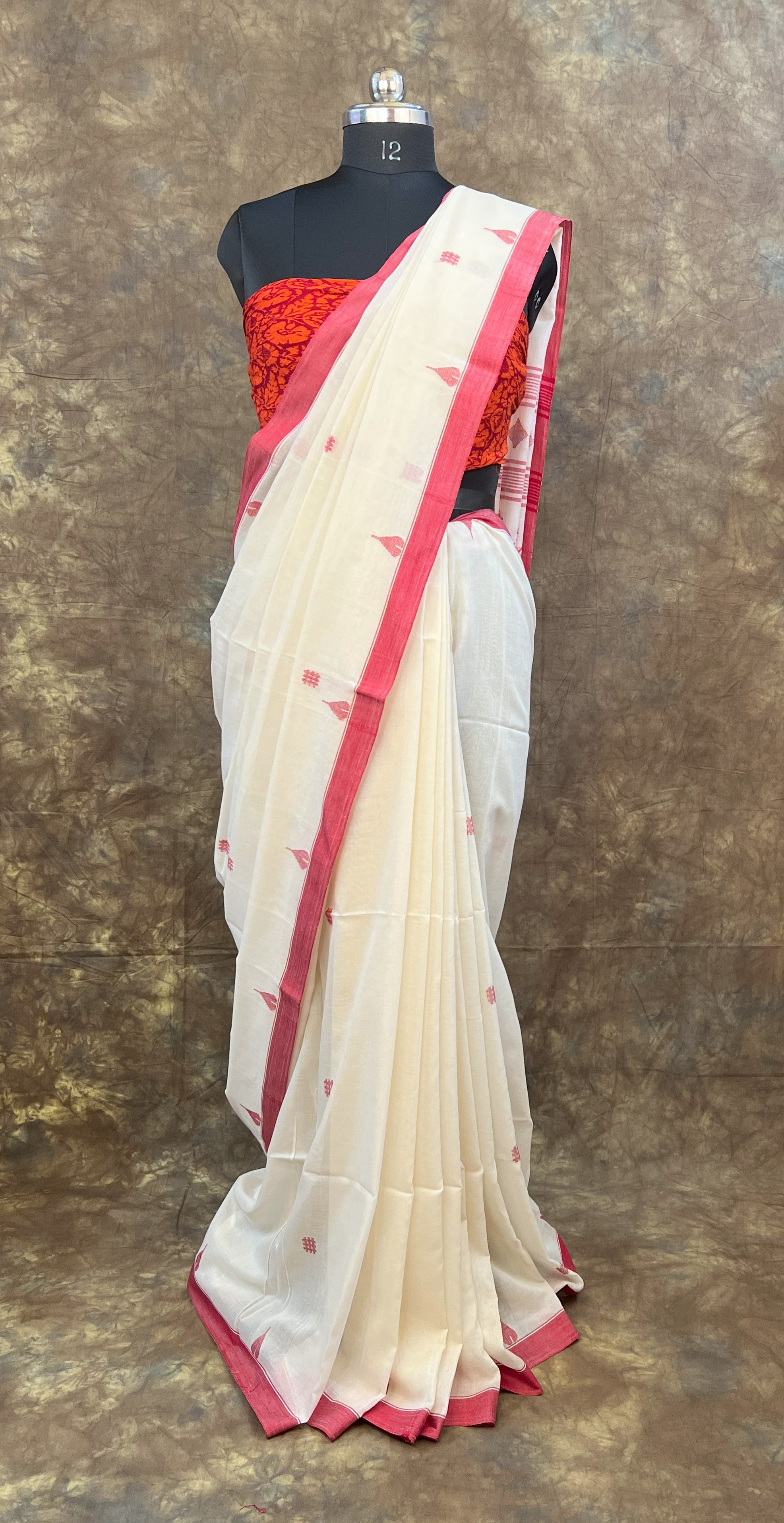 Designer red and white saree with traditional Bengali border for Puja.