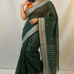 Woman wearing green handloom cotton saree for Durga Puja.