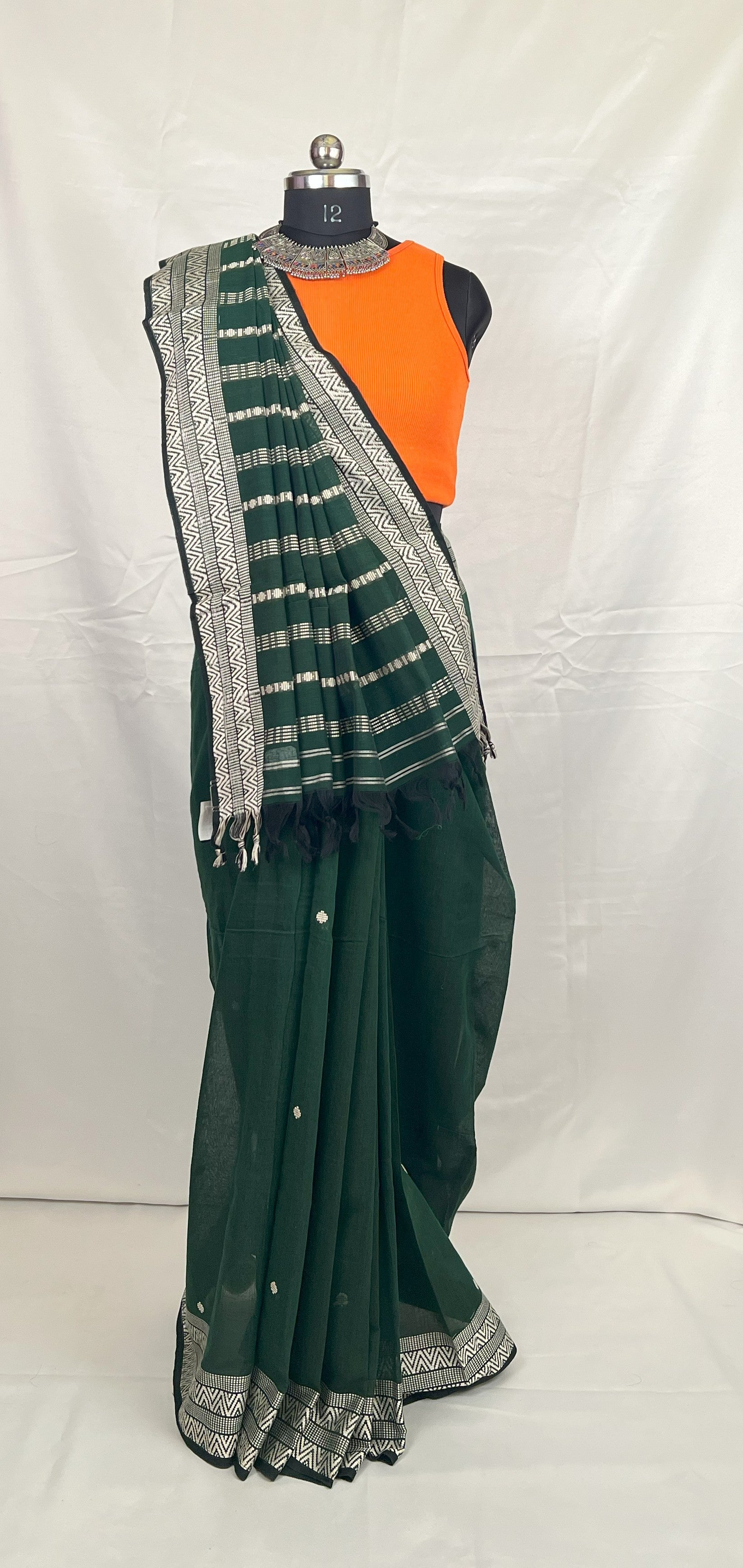 Close-up of woven motifs on green handloom cotton saree.