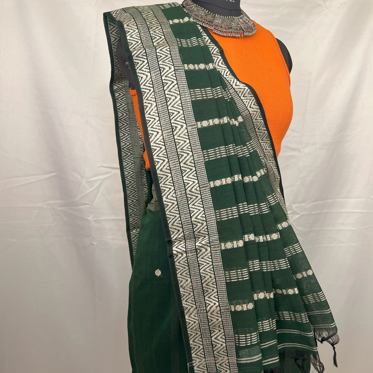 Green handloom saree styled with jewellery for wedding guest look.