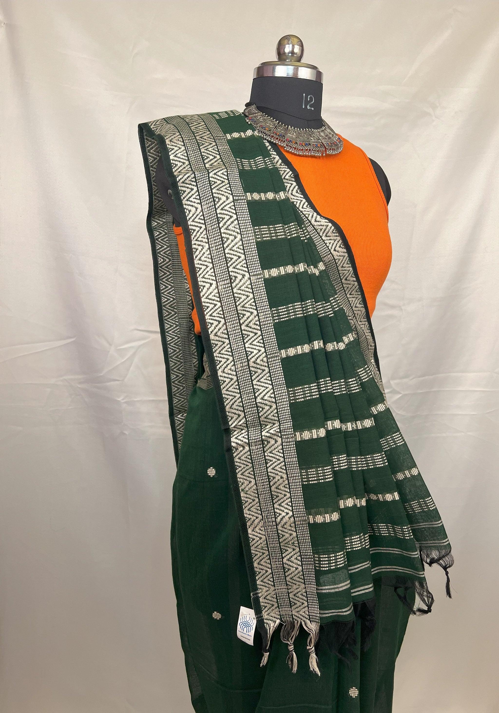 Green handloom saree styled with jewellery for wedding guest look.