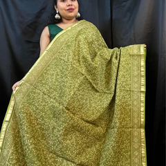 Woman draped in green Kota saree with woven white border