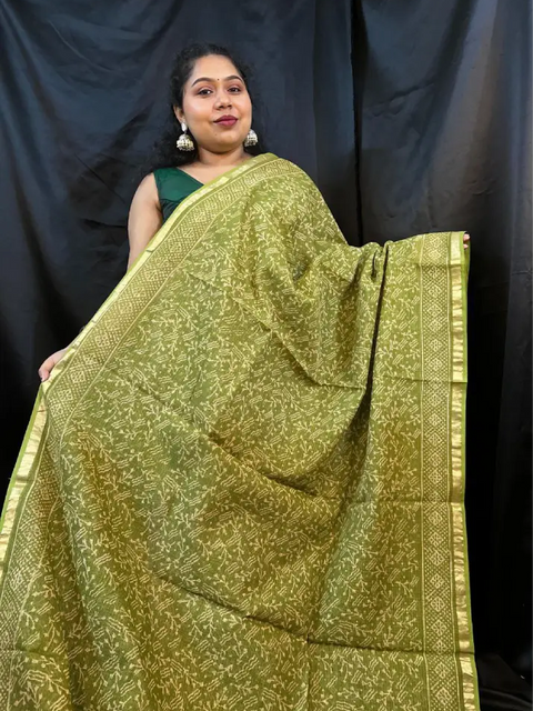Woman draped in green Kota saree with woven white border