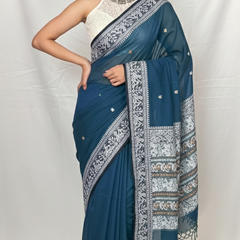 Close-up of Baluchari saree peacock blue cotton fabric with traditional white woven border.