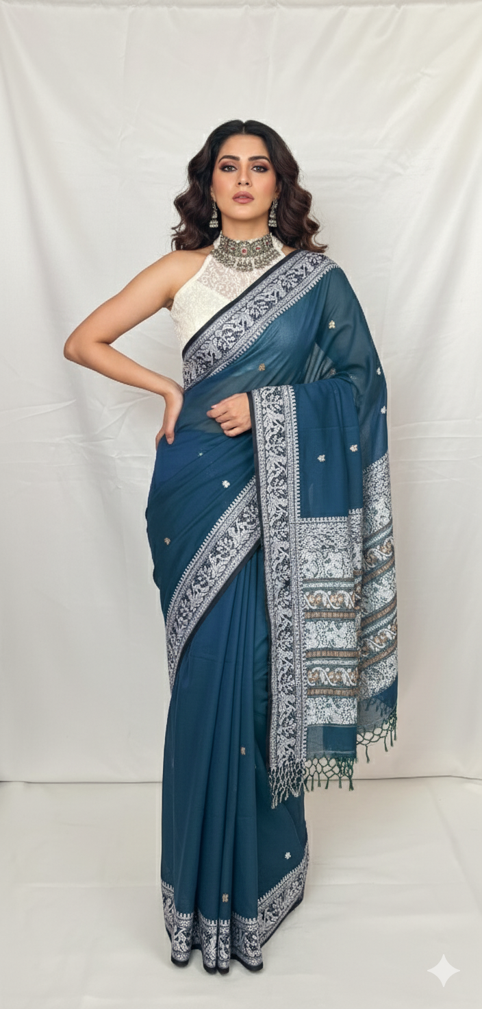 Close-up of Baluchari saree peacock blue cotton fabric with traditional white woven border.