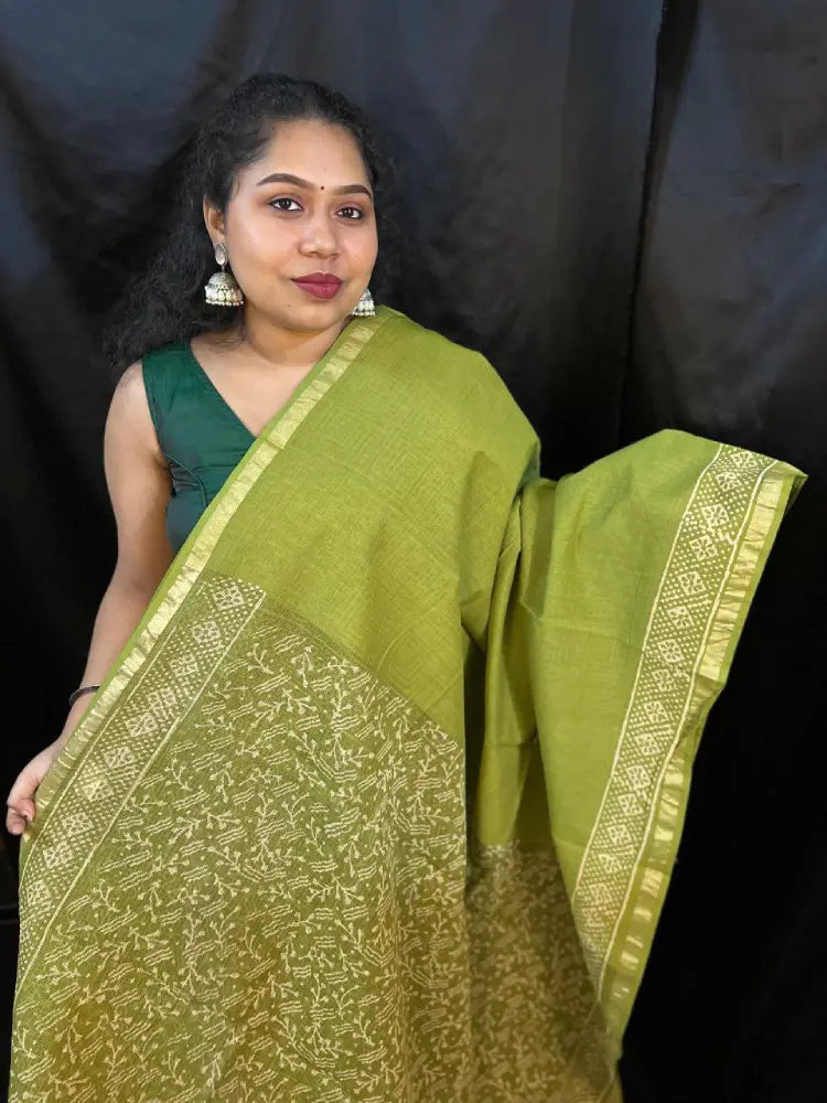 Detailed shot of Kota saree weaving pattern on green fabric