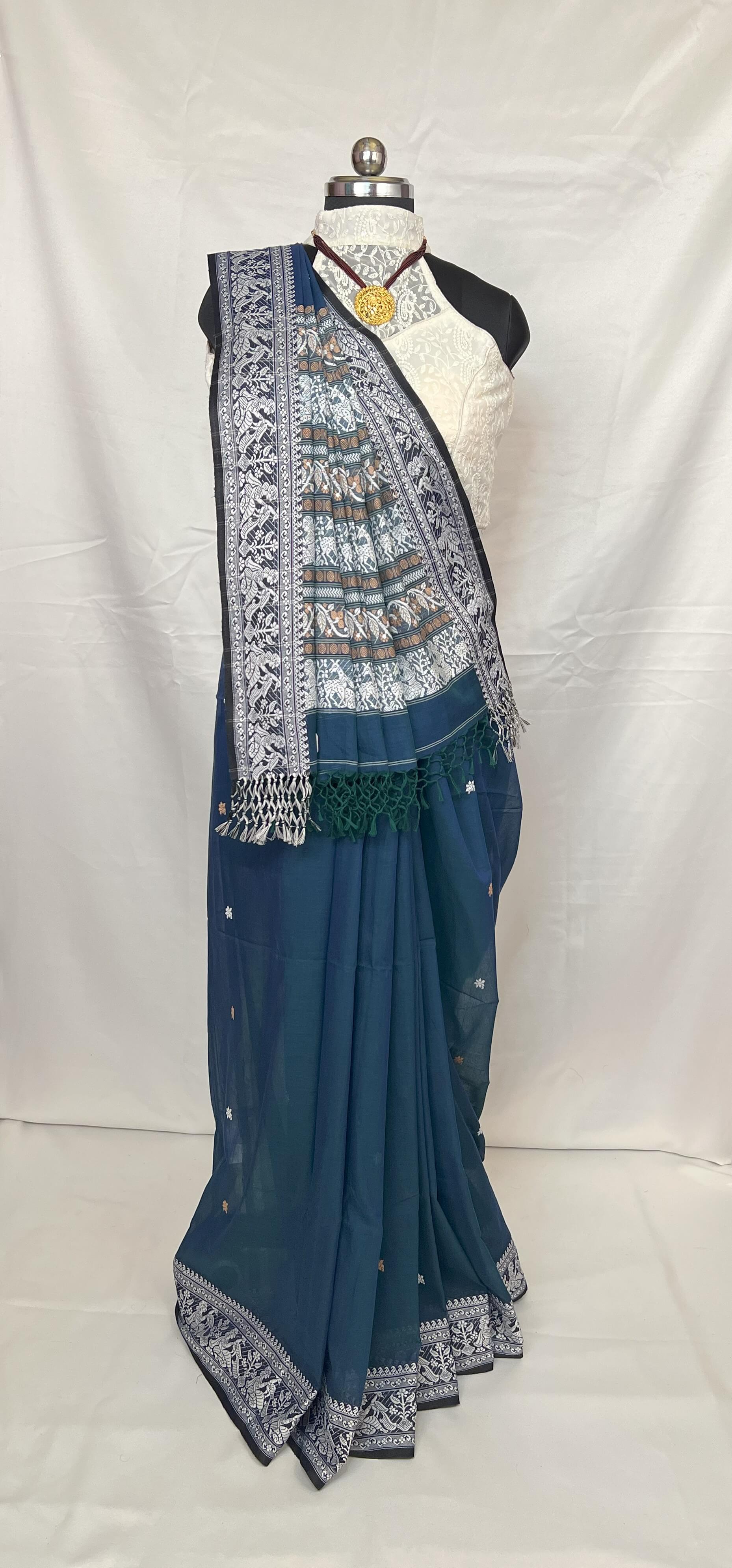 Traditional Bengal Baluchari cotton saree in peacock blue shade with classic woven patterns.