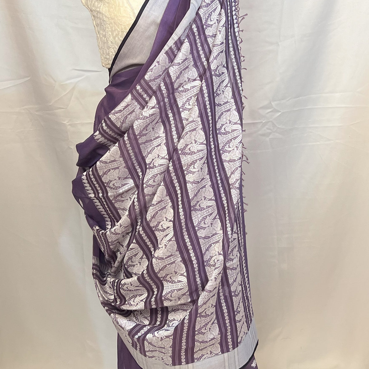 Purple Handloom Baluchari Saree styled with contrast white embroidered blouse.