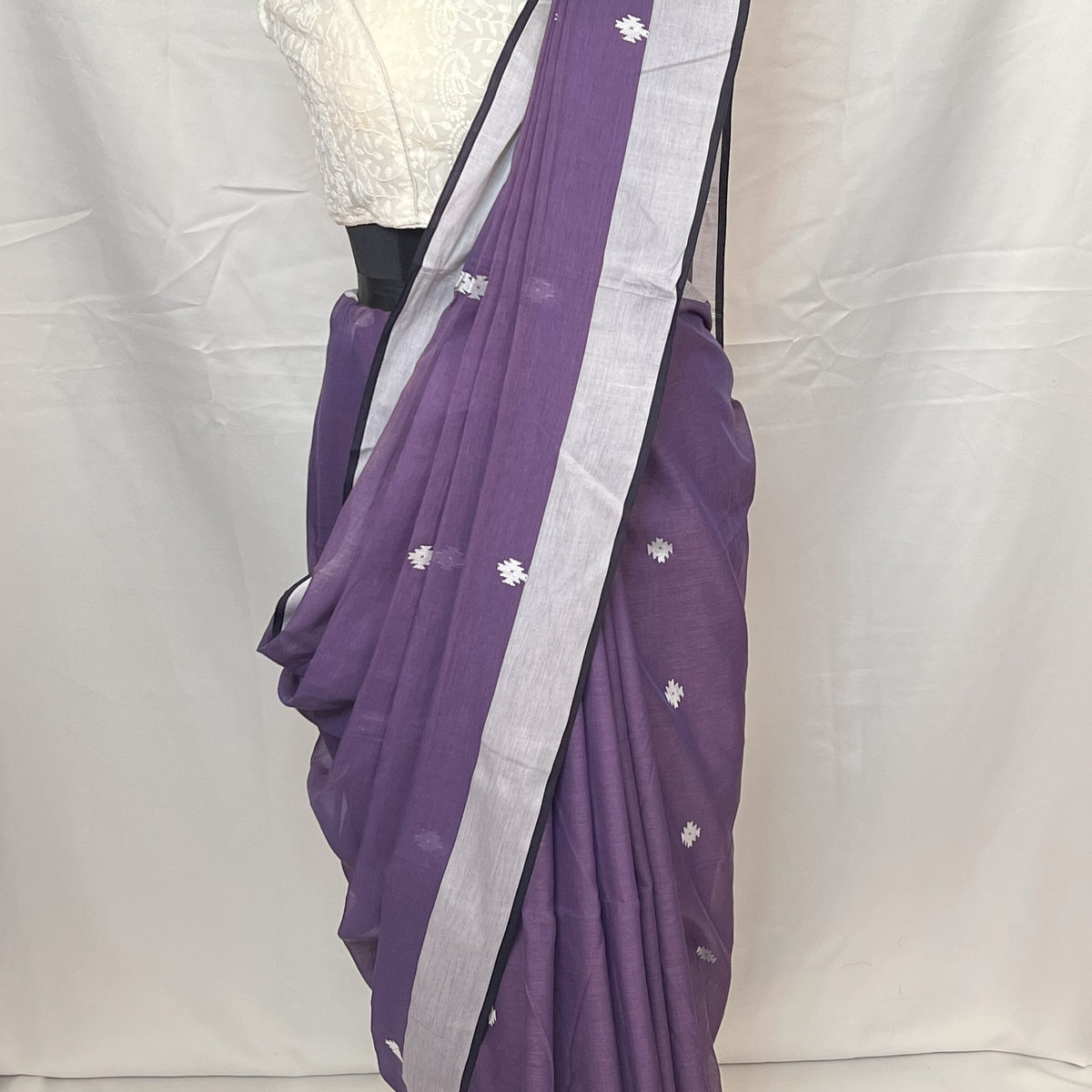 Draped mannequin showcasing Purple Cotton Baluchari Saree with intricate motifs.