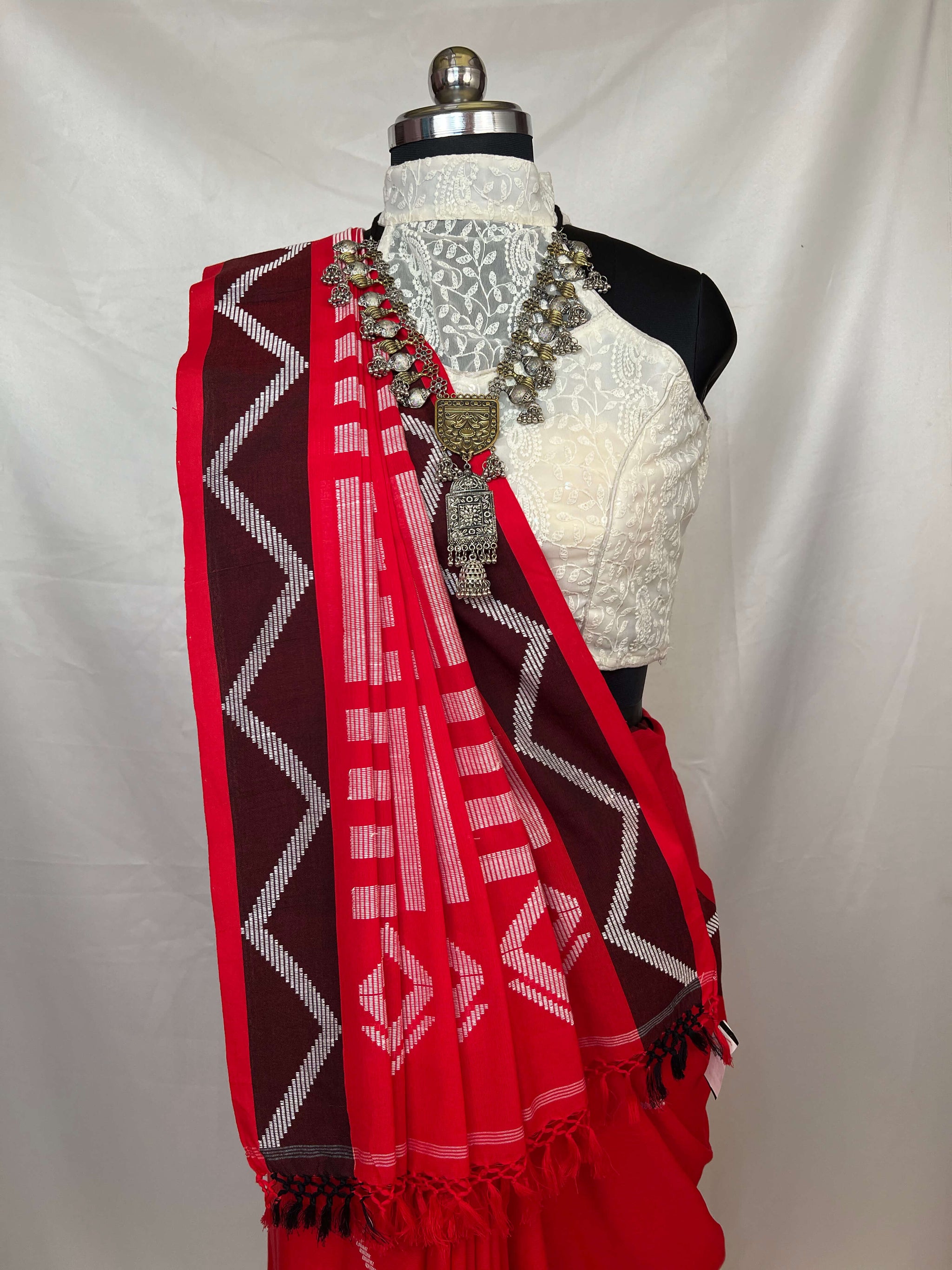 Traditional red white cotton handloom saree showcasing authentic weaving and ethnic style.