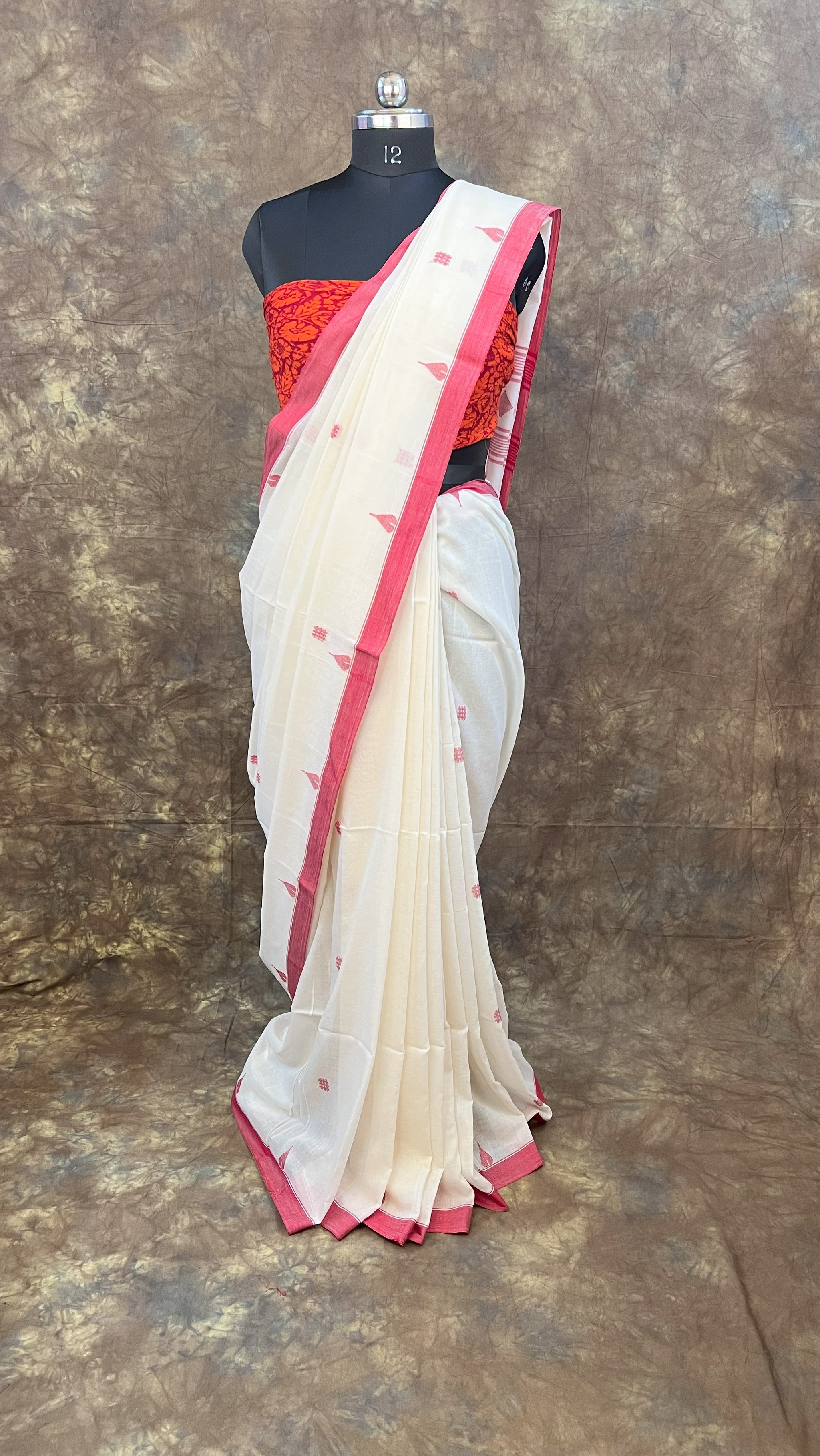 Elegant red and white saree styled for Sindoor Khela during Durga Puja.
