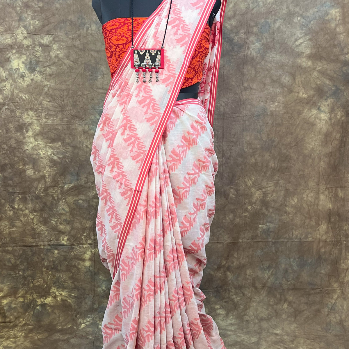 Traditional red and white cotton saree styled for festive Durga Puja celebrations.