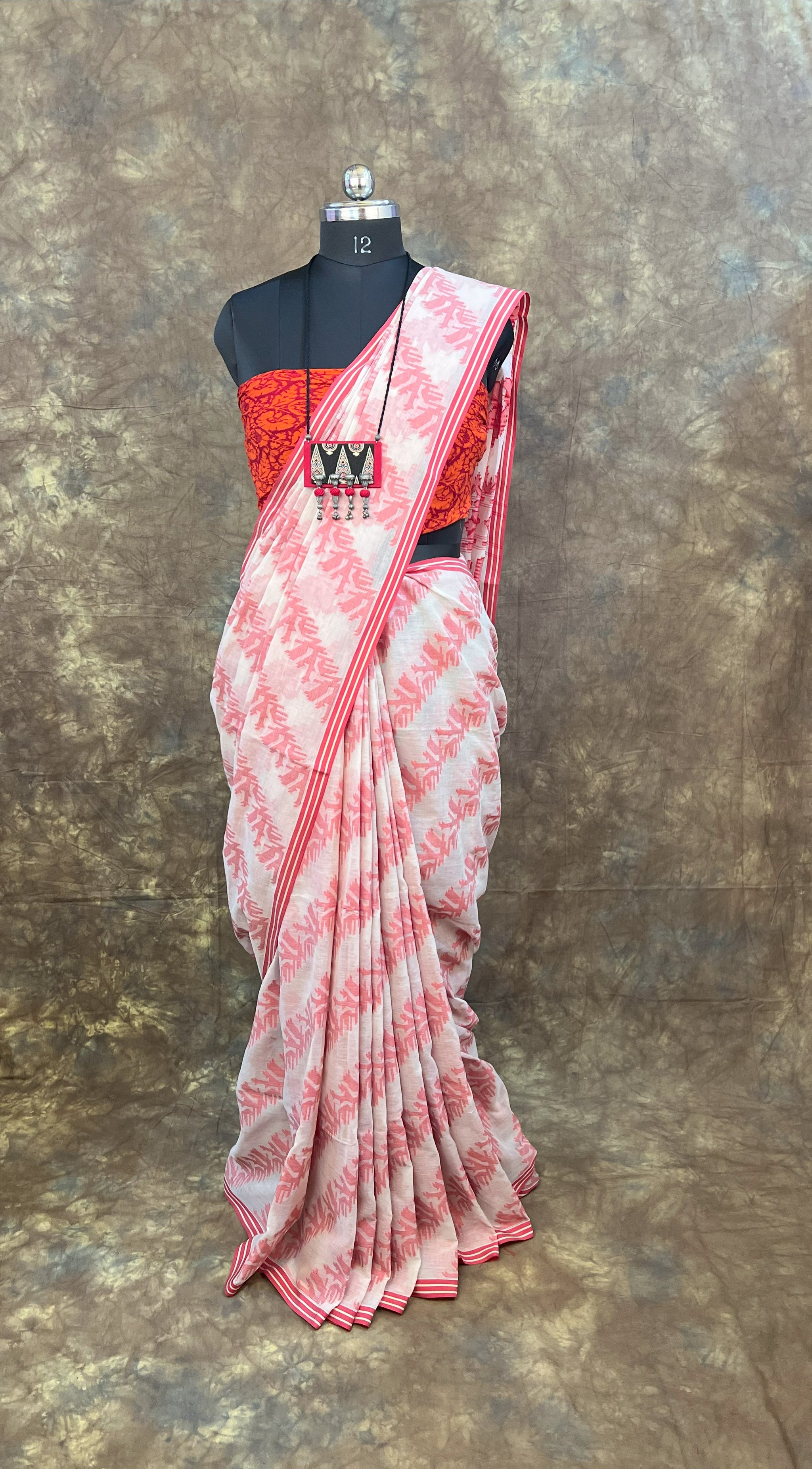 Traditional red and white cotton saree styled for festive Durga Puja celebrations.