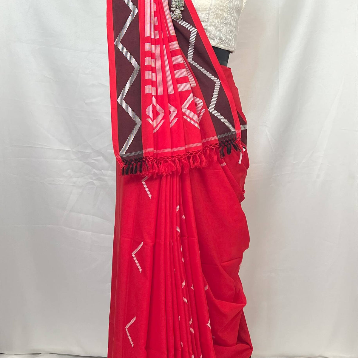 White and red handloom cotton saree with geometric stripe design, breathable cotton fabric for all-day comfort.