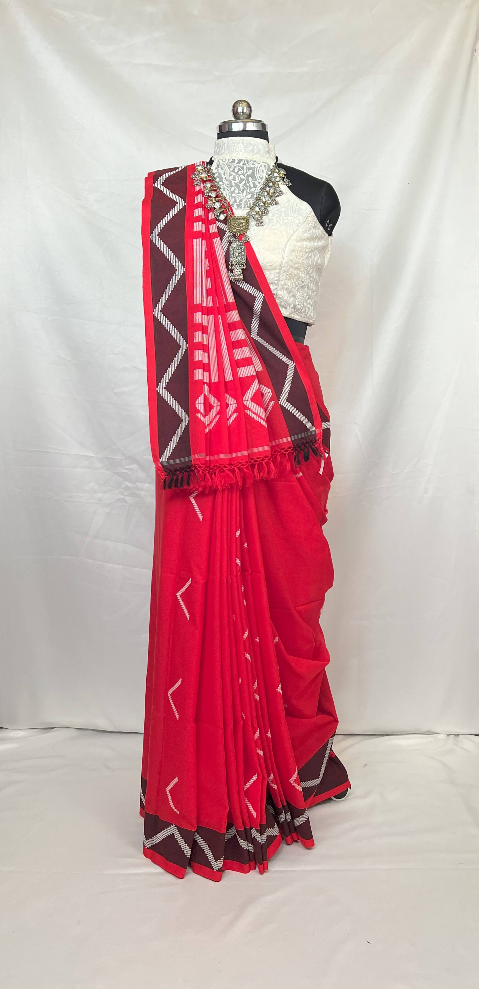 White and red handloom cotton saree with geometric stripe design, breathable cotton fabric for all-day comfort.